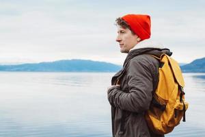 portret van een reiziger die op de achtergrond van de bergen en het meer staat foto