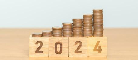 2024 jaar blok met munten stapel. geld, begroting, belasting, investering, financieel, spaargeld en nieuw jaar resolutie concepten foto