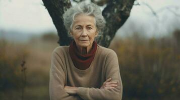 een verdrietig senior vrouw op zoek Bij camera buitenshuis in natuur foto