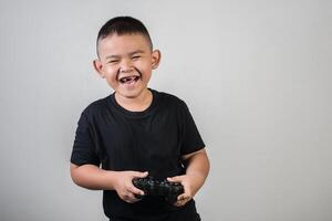 gelukkige jongen speel spelcomputer met een controller in studiofoto foto