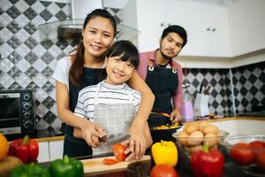 gelukkige familie helpt bij het koken van maaltijd samen in de keuken thuis. foto