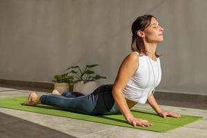jonge vrouw die yoga cobra pose beoefent foto