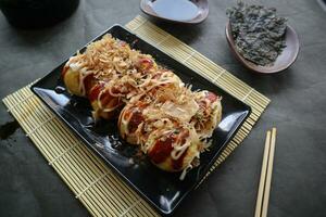 takoyaki is een Japans voedsel, gemaakt van tarwe meel deeg, Octopus vlees, of andere vullingen, geserveerd met saus, mayonaise en topping in de het formulier van katsuobushi of hout vis schaafsel. foto