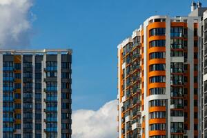 vers gebouwd hoog stijgen appartement gebouwen Aan blauw lucht achtergrond met wit wolken foto