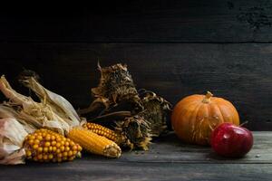 herfst oogst concept met maïs squash zonnebloemen en appels Aan rustiek achtergrond foto