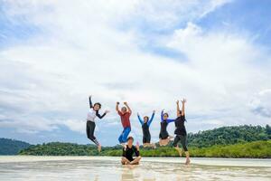 gelukkig familie jumping samen Aan de strand, Thailand foto