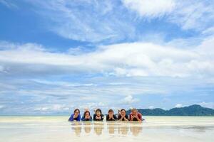 gelukkig familie aan het liegen samen Aan de strand, Thailand foto