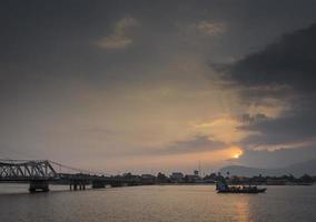 mijlpaal oude brug en rivier bij zonsondergang in kampot cambodja foto