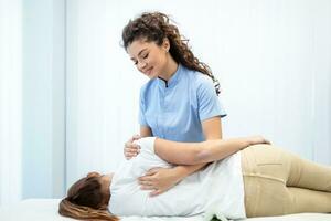 dichtbij omhoog van vrouw osteopaat aan het doen schouder blad behandeling Aan jong vrouw. foto