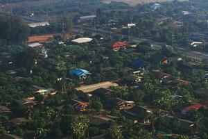 antenne visie van daken van groen veld- met dorp huizen in de platteland in noordelijk van Thailand. foto