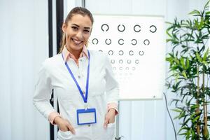 detailopname van vrouw oogarts testen geduldig met brieven Aan speciaal bord. kopiëren ruimte in links kant. professioneel aantrekkelijk oog dokter in kantoor Bij ziekenhuis. modern geneeskunde concept foto