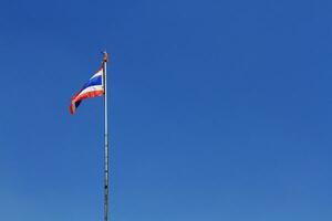 nationaal vlag van Thailand is golvend Aan pool met blauw lucht achtergrond foto