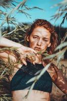 vrouw in bikini op een tropisch strand met planten foto