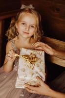 schattig klein meisje in roze jurk met cadeau