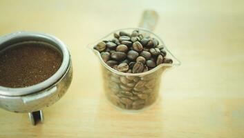 bonen koffie in glas en filterhouder gevulde met geaard koffie foto