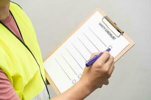 actie van veiligheid officier is schrijven en controleren Aan checklist document gedurende veiligheid audit en inspectie. veiligheid checklist vel naar verifiëren werken voorwaarde. foto