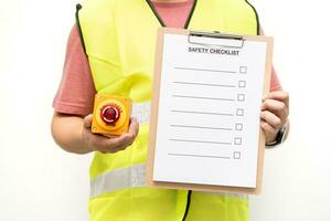 Mens Holding blanco checklist en noodgeval hou op knop. veiligheid checklist papier gedurende veiligheid audit en risico verificatie. conceptuele onderschrift veiligheid controlelijst. foto