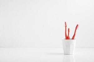 groep rode tandenborstel in een plastic beker, tandenborstel in de badkamer foto