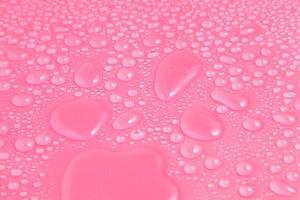 close-up waterdruppels op roze achtergrond foto