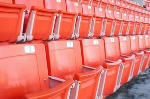 leeg oranje stoelen Bij stadion, rijen van stoel Aan een voetbal stadion foto