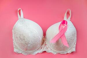 borst kanker bewustzijn maand. vrouwen beha en roze lint Aan helder achtergrond. Gezondheid zorg concept, oncologie diagnostiek. foto