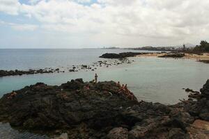 kust landschap met oceaan strand en blauw lucht Aan de eiland van Lanzarote in Spanje foto