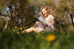 leuke vrouw rust in het park met paardebloemen foto