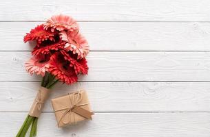 rode gerbera madeliefjebloemen en ambachtelijke geschenkdoos met labeltag foto