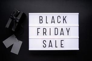 Black Friday-verkoopwoorden op lightbox met zwarte geschenkdoos en prijskaartjes foto