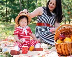 interraciale familie van moeder en dochter in het park met een picknick foto