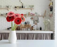 keuken interieur vooraanzicht van heldere gerbera madeliefjes in een vaas foto