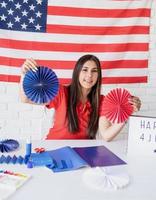 vrouw die papieren fans van rood en blauw maakt en de onafhankelijkheidsdag viert foto