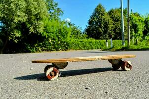 een skateboard zittend Aan de grond met een boom in de achtergrond foto