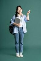 portret van een mooi Aziatisch leerling Aan een groen achtergrond foto