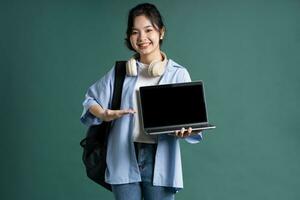 portret van een mooi Aziatisch leerling Aan een groen achtergrond foto