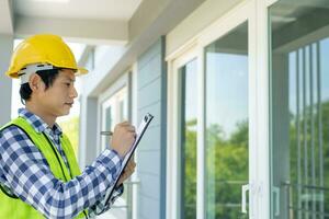 inspecteur of ingenieur is inspecteren bouw en kwaliteit zekerheid nieuw huis gebruik makend van een controlelijst. ingenieurs of architecten of contactor werk naar bouwen de huis voordat overhandigen het over- naar de huiseigenaar foto