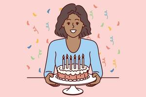 tiener- meisje met verjaardag taart in handen glimlacht, aanbieden naar vieren vakantie partij foto