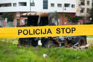 Bosnisch Politie plakband barricaderen een verbrand vrachtauto foto