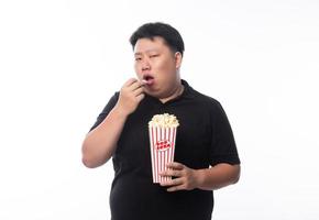 jonge grappige dikke aziatische man die popcorn eet foto
