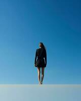 een bevallig vrouw staat Aan een ongerept wit oppervlak, ingelijst door een sereen blauw lucht in de achtergrond.. generatief ai foto