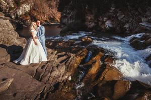 echtpaar omarmen met een berg en rivier achtergrond