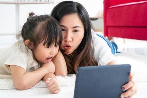 moeder en dochter kijken naar een tekenfilm op een tablet foto