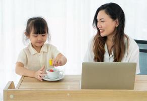 moeder en dochter aan tafel met laptop foto