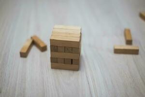 toren van houten blokken Aan de helder vloer. houten stokjes verspreide met kinderen spellen. foto