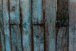 de oud hek met houten planken met gescheurd blauw verf foto
