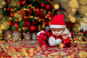 weinig zes maand oud baby gekleed net zo de kerstman claus. achtergrond voor Kerstmis kaart. de kind looks naar beneden Bij de plaats voor inscriptie. foto