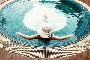 vrouw in zwembroek is ontspannen in het zwembad foto