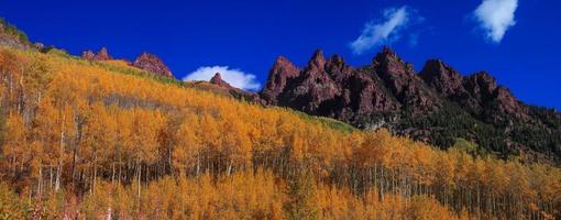 panoramisch uitzicht op rotsachtige bergen omgeven door helder herfstgebladerte