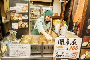 osaka, oke, 2018 - Japans vrouw handelaar en haar Japans tussendoortje o-den winkel. het is een voedsel dat combineert een verscheidenheid van voedingsmiddelen en populair naar gegeten in de winter. foto