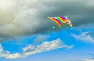 regenboog vlieger vliegend in blauw lucht met wolken in zomer met copyspace foto